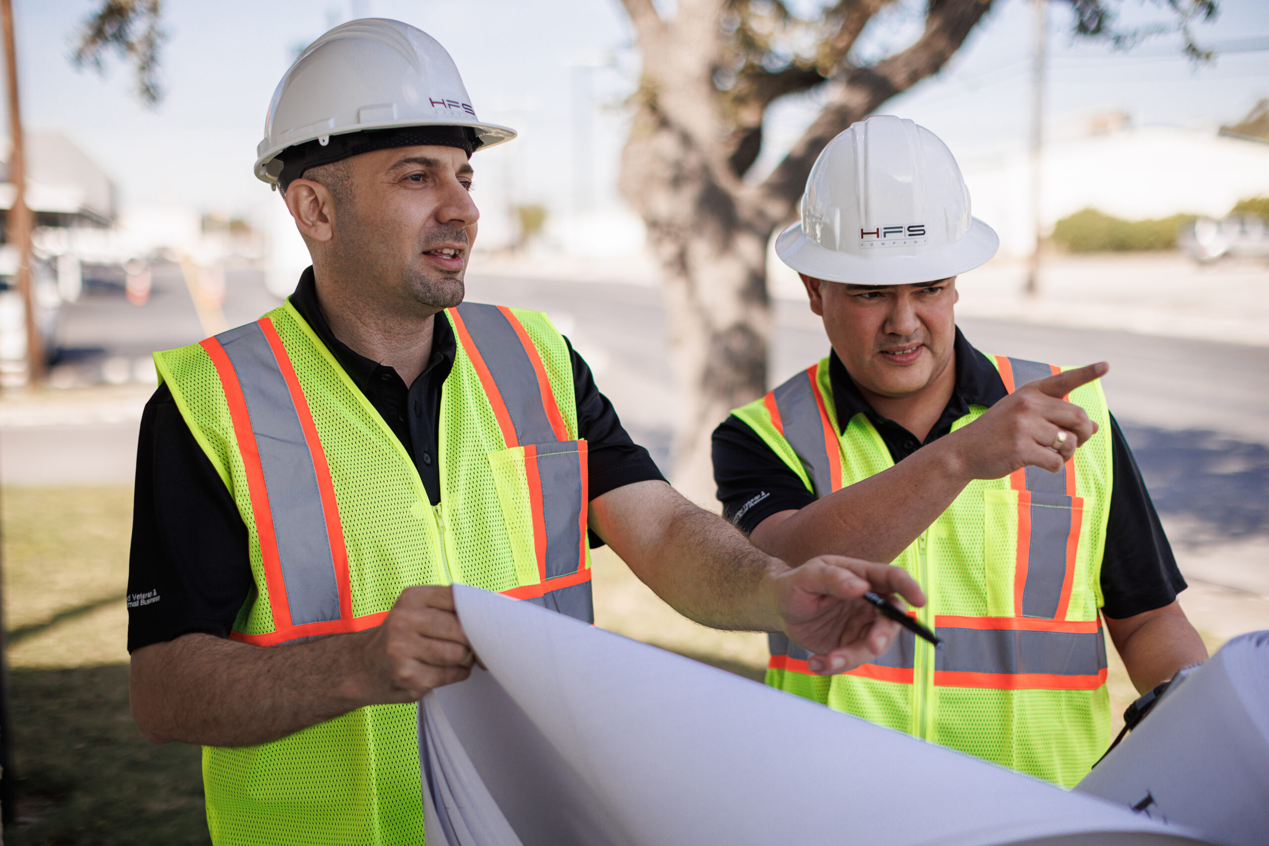 Two Engineers wearing HFS hardhats and hi vis vests